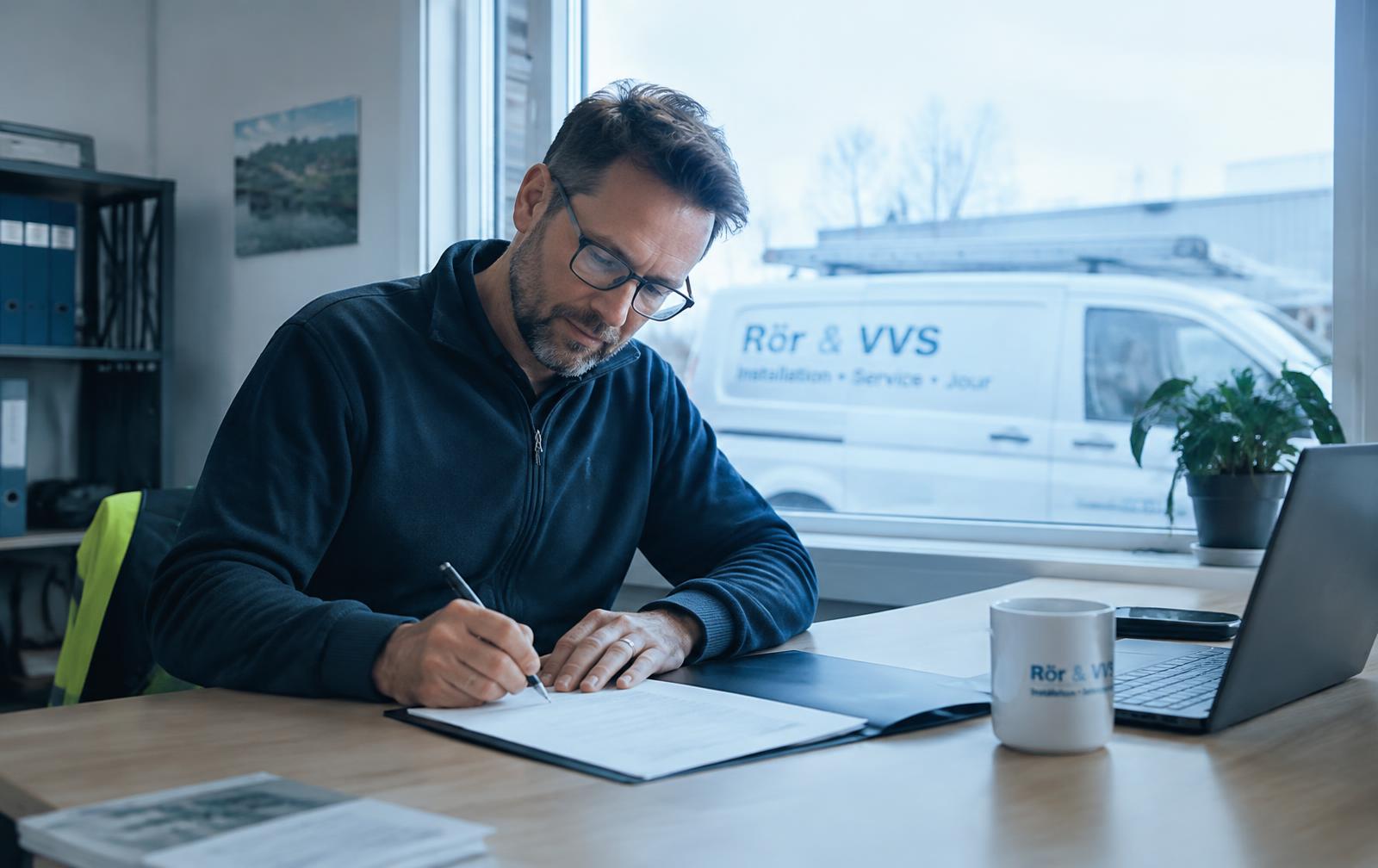 Hantverkare skriver under ett avtal vid skrivbordet med firmabilen utanför fönstret
